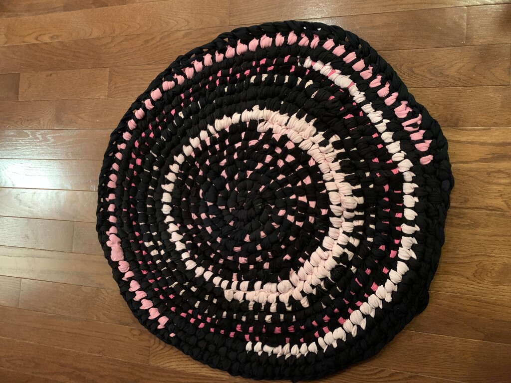Black and Pink Round Amish Knot Rug Recovering Hands
